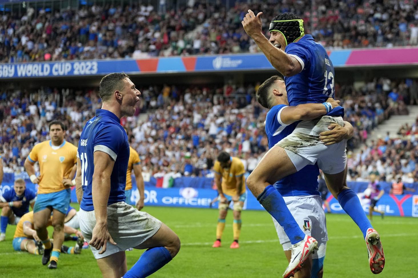 Italy's Juan Ignacio Brex, right, celebrates with teammates after scoring a try.